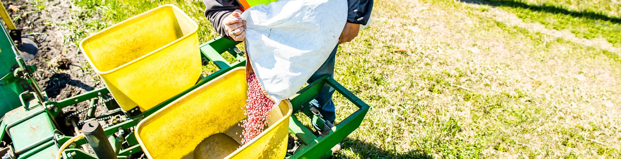 person putting seed into a planter