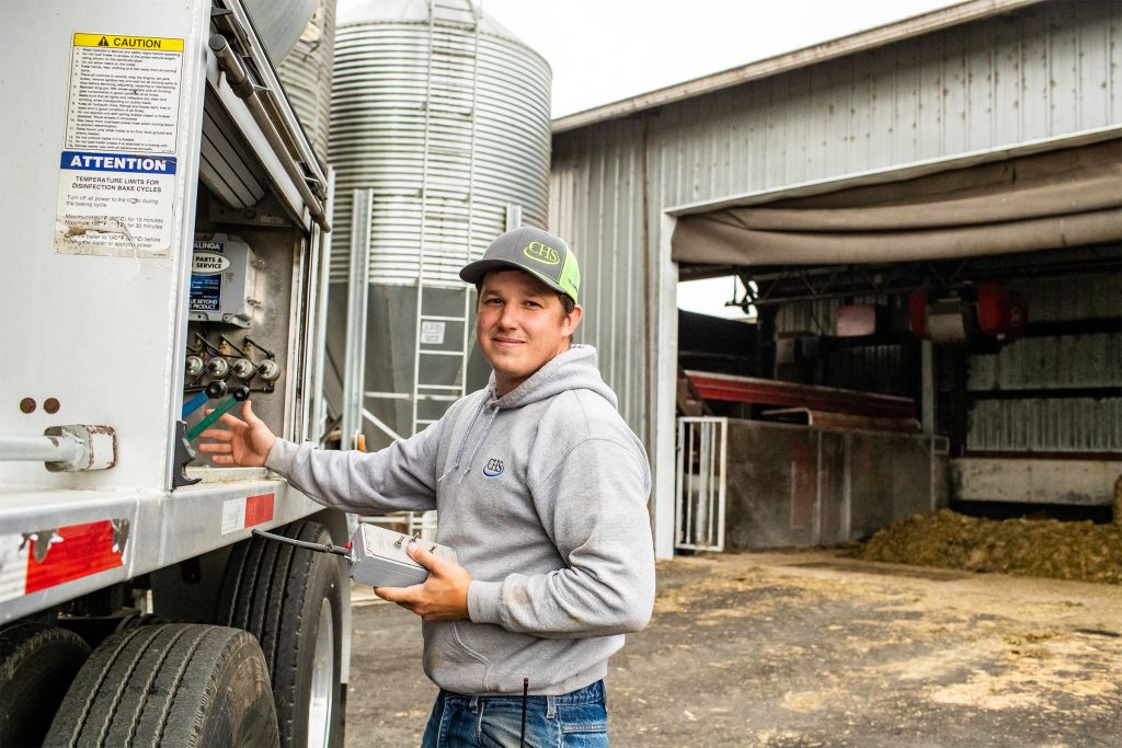 A student with CHS branded hat next to truck